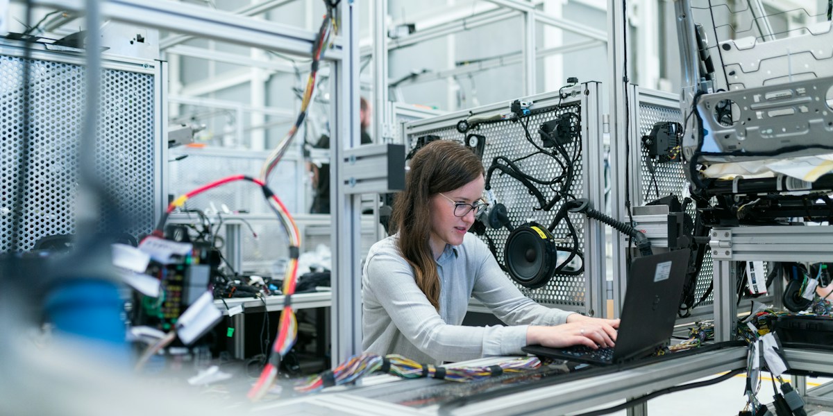 Pracownica korzystająca z laptopa na stanowisku produkcyjnym